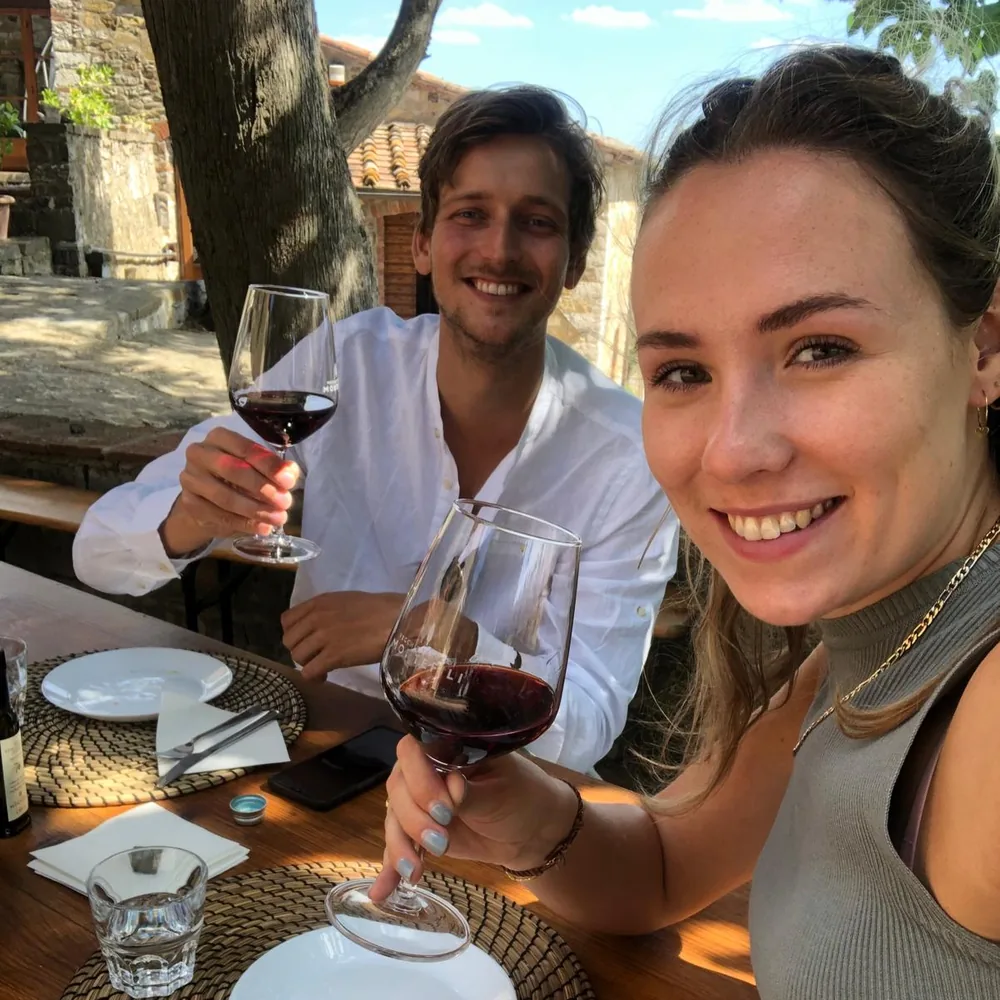 Sabine en Finn proosten met rode wijn bij wijnhuis Vecchie Terre di Montefili in Toscane.